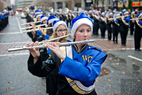 Breanna Jones (center) plays her flute with the White Co. High School band as they march down Peachtree St. during the 2014 Children's Christmas Parade in Atlanta on Saturday, December 6, 2014. 