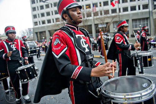 Andrew Sealer (center) plays his snare drum with the Tri-Cities High School band as they march down Peachtree St. during the 2014 Children's Christmas Parade in Atlanta on Saturday, December 6, 2014. 