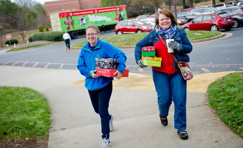 Anna Payton Weaver (left) and her mother Sharon drop off shoe boxes full of toys, school supplies and essentials that will be shipped to countries all over the world at the Samaritan's Purse packaging center in Suwanee for their Operation Christmas Child campaign on Tuesday, December 9, 2014. 