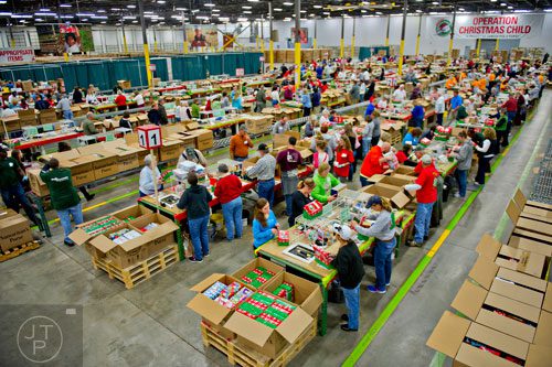 Volunteers work to package shoe boxes full of toys and essentials that will be shipped to countries all over the world at the Samaritan's Purse packaging center in Suwanee for their Operation Christmas Child campaign on Tuesday, December 9, 2014.