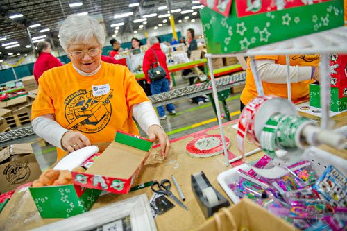 Mary Singleton sorts through shoe boxes full of toys, school supplies and essentials that will be shipped to countries all over the world at the Samaritan's Purse packaging center in Suwanee for their Operation Christmas Child campaign on Tuesday, December 9, 2014. 