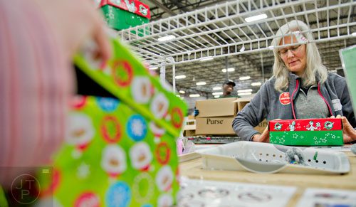 Jenny Hanson (right) sorts through shoe boxes full of toys, school supplies and essentials that will be shipped to countries all over the world at the Samaritan's Purse packaging center in Suwanee for their Operation Christmas Child campaign on Tuesday, December 9, 2014. 
