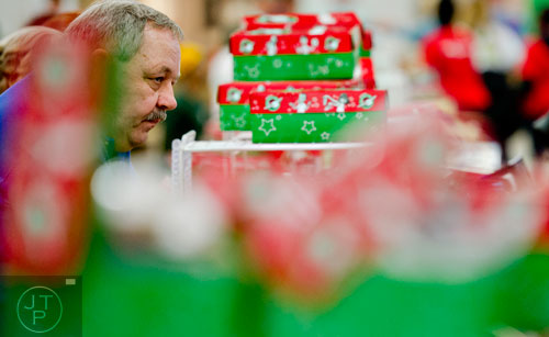 Wayne Coleman (left) sorts through shoe boxes full of toys, school supplies and essentials that will be shipped to countries all over the world at the Samaritan's Purse packaging center in Suwanee for their Operation Christmas Child campaign on Tuesday, December 9, 2014.