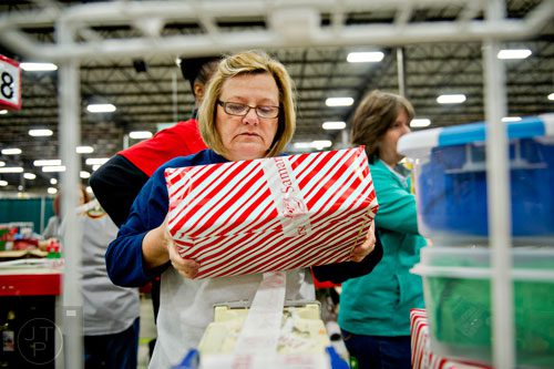 Karen Tabb tapes up a shoe box full of toys and essentials that will be shipped to countries all over the world at the Samaritan's Purse packaging center in Suwanee for their Operation Christmas Child campaign on Tuesday, December 9, 2014. 