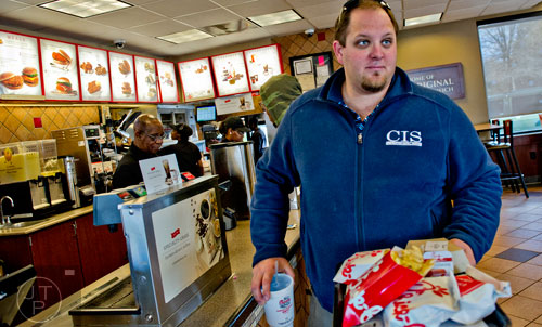 Nick Smith (right) walks to his seat carrying lunch for he and his friends  at the Chick-fil-A off of Camp Creek Parkway in East Point on Wednesday, December 10, 2014. 