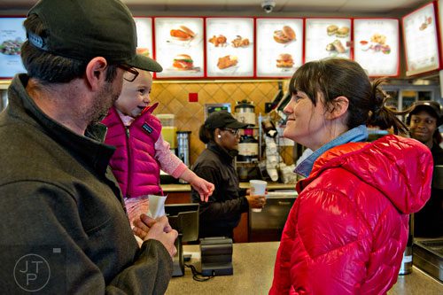 Colin McChesney (left) holds his daughter Evan as they and his wife Jessica wait on their food at the Chick-fil-A off of Camp Creek Parkway in East Point on Wednesday, December 10, 2014. 