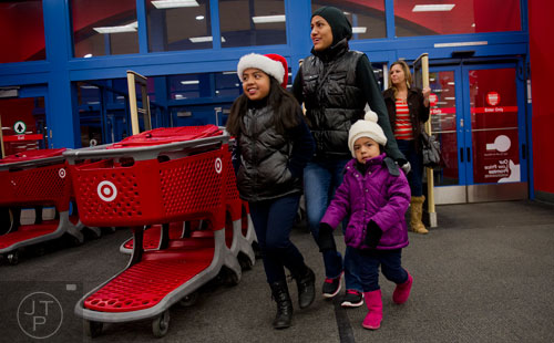 Haidee Quechol (left) her mother Beatrice and sister Kayla walk inside before the start of the first annual Brookhaven Police Shop with a Badge event at the Target off of North Druid Hills in Atlanta on Saturday, December 13, 2014. 