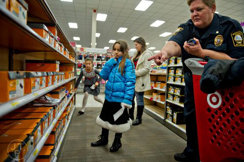 Brookhaven Police Maj. Linda Burke (right) points out a pair of size two shoes to Dulce Ballin as they shop during the first annual Brookhaven Police Shop with a Badge event at the Target off of North Druid Hills in Atlanta on Saturday, December 13, 2014. 