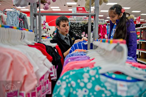 Brookhaven dispatcher Harrison Siegfried (left) helps Fernanda Valdez pick out clothes during the first annual Brookhaven Police Shop with a Badge event at the Target off of North Druid Hills in Atlanta on Saturday, December 13, 2014.