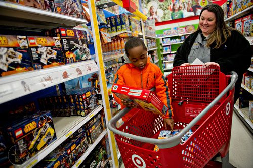 Joshua Alaman (left) tries to decide which LEGO sets to buy as he shops with Brookhaven dispatcher Shannon Parham during the first annual Brookhaven Police Shop with a Badge event at the Target off of North Druid Hills in Atlanta on Saturday, December 13, 2014. 