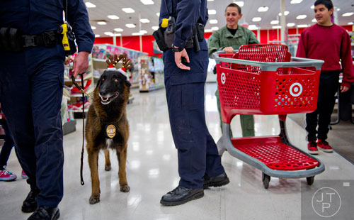 Brookhaven Police K-9 officer Grizz looks around as Ofc. Patrick Dicicco and Alan Reyes continue to shop during the first annual Brookhaven Police Shop with a Badge event at the Target off of North Druid Hills in Atlanta on Saturday, December 13, 2014. 