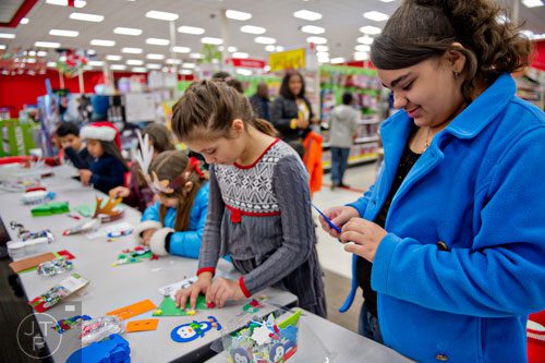 Angelina Ward (right) makes a Christmas ornament during the first annual Brookhaven Police Shop with a Badge event at the Target off of North Druid Hills in Atlanta on Saturday, December 13, 2014. 