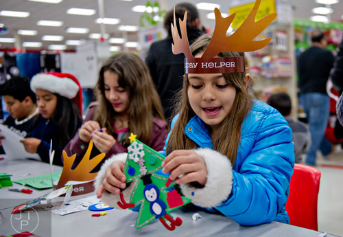 Dulce Ballin (right) plays with her newly made Christmas ornament during the first annual Brookhaven Police Shop with a Badge event at the Target off of North Druid Hills in Atlanta on Saturday, December 13, 2014.