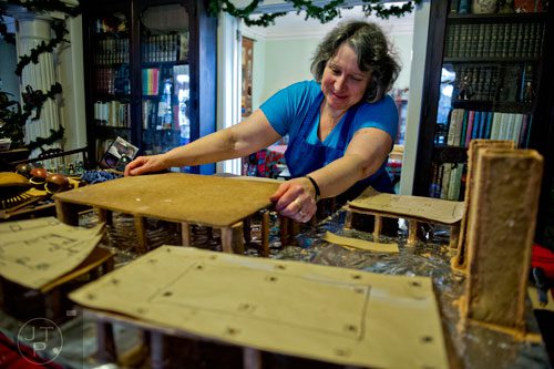 Emily Wert places a baseboard for a gingerbread house as she works on a replica of Laketown from "The Hobbit" movies at her home in Atlanta on Friday, December 12, 2014. 