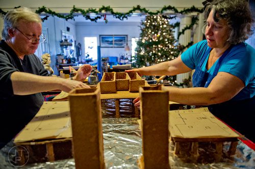 Emily Wert (right) and her husband Jim work on a replica of Laketown from "The Hobbit" movies made of gingerbread at their home in Atlanta on Friday, December 12, 2014. 