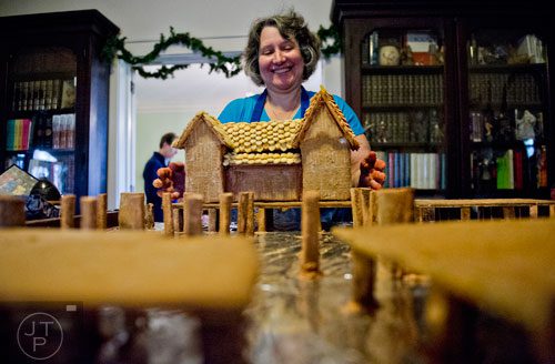 Emily Wert places gingerbread houses as she works on a replica of Laketown from "The Hobbit" movies at her home in Atlanta on Friday, December 12, 2014.