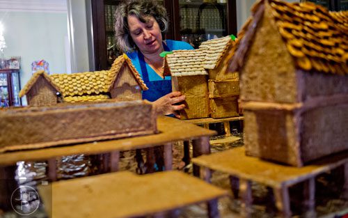Emily Wert places gingerbread houses as she works on a replica of Laketown from "The Hobbit" movies at her home in Atlanta on Friday, December 12, 2014.