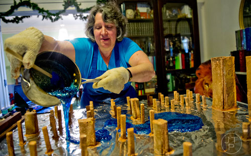Emily Wert pours molten sugar onto the base of her Laketown gingerbread model from "The Hobbit" movies at her home in Atlanta on Friday, December 12, 2014. 