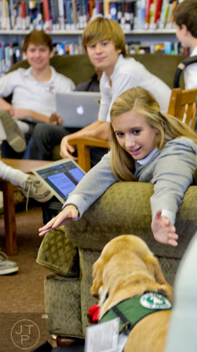 Camryn Landis (right) reaches out to pet Pirelli, a dog with the Canine Assistants program, as she takes a break from studying for final exams at Holy Innocents' Episcopal School in Atlanta on Friday, December 19, 2014. 