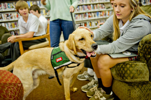 Camryn Landis (right) pets Adidas, a golden retriever with the Canine Assistants program, as she takes a break from studying for final exams at Holy Innocents' Episcopal School in Atlanta on Friday, December 19, 2014. 
