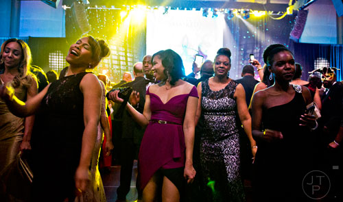 Trayce Toles (left), Shainna Gibson and other guests dance as Chaka Khan performs on stage during the 31st annual United Negro College Fund Mayor's Masked Ball at the Atlanta Marriott Marquis in downtown on Saturday, December 20, 2014.