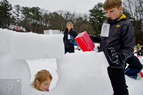 Cayden Bevis (right) and his sister Raelynn build an igloo during Snow Mountain at Stone Mountain Park on Sunday, December 21, 2014. 