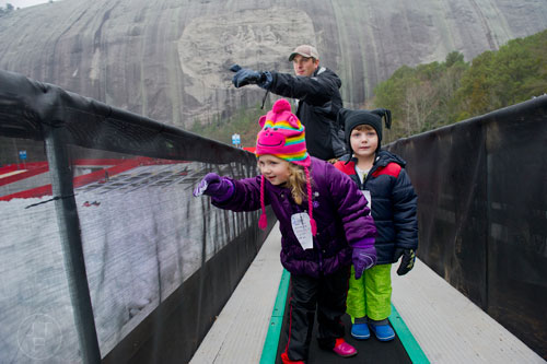 Emilie Hart (center), her cousin Hunter Futrell (right) and Hunter's father John bring their tubes to the top of the hill during Snow Mountain at Stone Mountain Park on Sunday, December 21, 2014. 