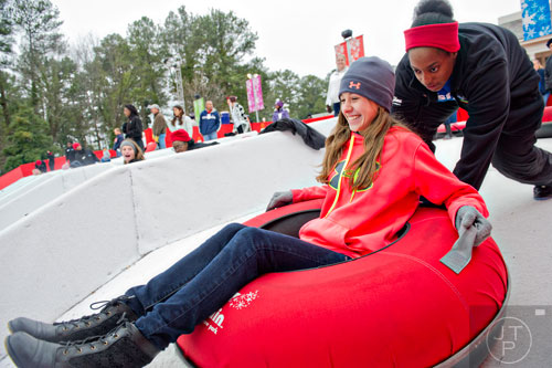 Jordan Britt (left) closes her eyes as Shaniqua Whyte pushes her tube down the hill during Snow Mountain at Stone Mountain Park on Sunday, December 21, 2014. 