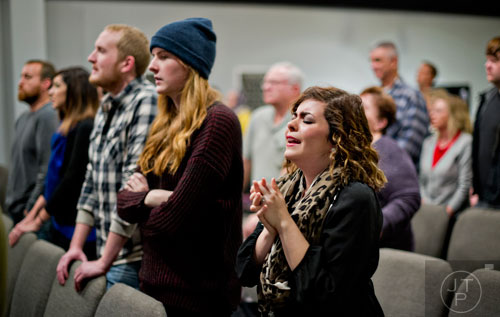 Daniela Lueke (center) sings during worship service at Crosspointe Church in Peachtree City on Sunday, December 21, 2014. 