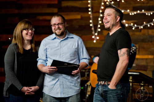Pastor Josiah Potter (right) stands in front of his congregation with Michael Nelson and his wife Amy during worship service at Crosspointe Church in Peachtree City on Sunday, December 21, 2014. 