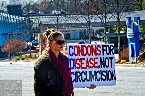 Kelley Heitzman holds a sign opposing circumcision across the street from the Center for Disease Control in Atlanta on Friday, December 12, 2014. 