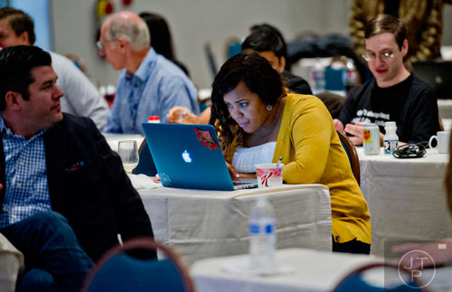 Crystal Gardner (center) works on her computer as she makes last minute adjustments before helping pitch her team's app to a panel of judges during The Weather Channel's Hack-A-Thon at the Atlanta Marriott Northwest at Galleria on Friday, December 12, 2014. 