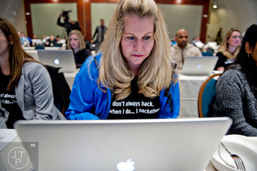 Jamie Molnar (center) works on her computer as she makes last minute adjustments before helping pitch her team's app to a panel of judges during The Weather Channel's Hack-A-Thon at the Atlanta Marriott Northwest at Galleria on Friday, December 12, 2014. 