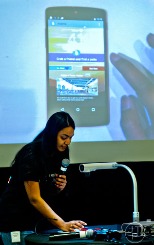 Krishna Chebrolu demonstrates an app with her team to a panel of judges during The Weather Channel's Hack-A-Thon at the Atlanta Marriott Northwest at Galleria on Friday, December 12, 2014. 