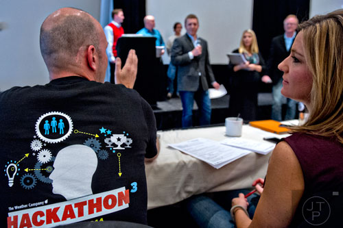 Judges Kevin Doerr (left) and Jen Carfagno (right) ask questions to one of numerous teams pitching app ideas during The Weather Channel's Hack-A-Thon at the Atlanta Marriott Northwest at Galleria on Friday, December 12, 2014. 