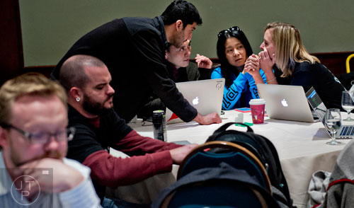 Krista Rouse (right) holds a last minute meeting with team members Ronnie Wu, Jeff Lu and Girdhar Malhotra before pitching their app to a panel of judges during The Weather Channel's Hack-A-Thon at the Atlanta Marriott Northwest at Galleria on Friday, December 12, 2014.