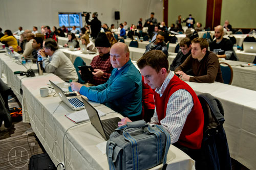 John Matthews (center) looks at his computer after pitching an app with his team to a panel of judges during The Weather Channel's Hack-A-Thon at the Atlanta Marriott Northwest at Galleria on Friday, December 12, 2014. 