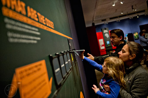 Eden Thome (left) is held by her mother Shani as they check out an interactive display in the Goosebumps: The Science of Fear exhibit at the Fernbank Museum of Natural History in Atlanta on Saturday, December 27, 2014.  
