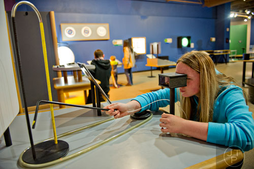 Tiara Conrey tries her depth perception in the Sensing Nature exhibit at the Fernbank Museum of Natural History in Atlanta on Saturday, December 27, 2014.