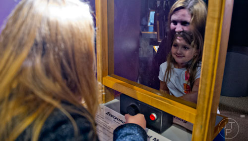 Ashley Medlock (left) and her sister Lauren play with light and mirrors in the Sensing Nature exhibit at the Fernbank Museum of Natural History in Atlanta on Saturday, December 27, 2014.  