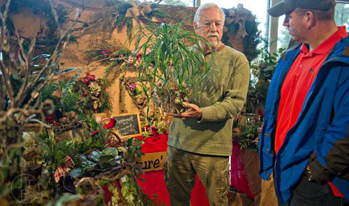 Larry Attig (left) talks to Gene Burell about the ponytail palm he holds in his hands during the Back-to-Nature Holiday Market and Festival at the Chattahoochee Nature Center in Roswell on Saturday, December 6, 2014. 