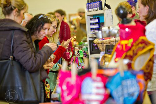 Michelle McCarty (center) looks at different holiday art during the Back-to-Nature Holiday Market and Festival at the Chattahoochee Nature Center in Roswell on Saturday, December 6, 2014.