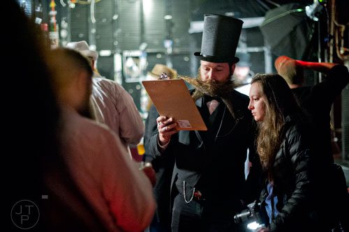 Josh Seehorn (center) stands next to Brittani Stanga as he registers for the 4th annual Battle of the Beards at Smith's Olde Bar in Atlanta on Saturday, December 13, 2014. 