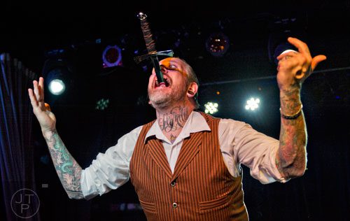 Captain Stab-Tuggp plays up to the crowd after swallowing a sword as he performs on stage during the 4th annual Battle of the Beards at Smith's Olde Bar in Atlanta on Saturday, December 13, 2014. 