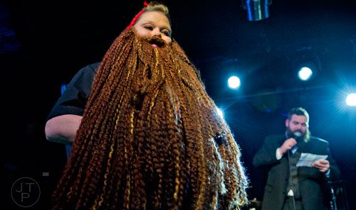 Staci McNellis (left) plays to the crowd as she competes in the Lady Beard competition as Mike Albanese emcees during the 4th annual Battle of the Beards at Smith's Olde Bar in Atlanta on Saturday, December 13, 2014. 