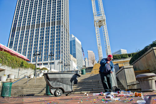 Doyle Hunter Jr. sweeps up trash and confetti at Underground Atlanta as crews try to clean up after the New Years Eve celebration on Thursday, January 1, 2015. 