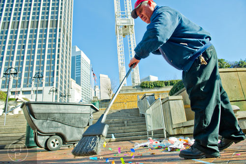 Doyle Hunter Jr. sweeps up trash and confetti at Underground Atlanta as crews try to clean up after the New Years Eve celebration on Thursday, January 1, 2015. 