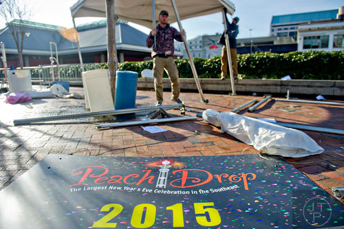 Justin Deutschle (left) and Sirron Bryan break down a pop up tent at Underground Atlanta as crews try to clean up after the New Years Eve celebration on Thursday, January 1, 2015. 