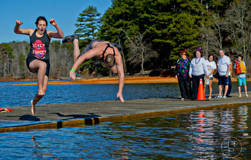Elizabeth Bucari (left) and Mike Nolan jump into Lake Lanier during the 18th annual Polar Bear Plunge at the Lanier Canoe & Kayak Club in Gainesville on Thursday, January 1, 2015. 