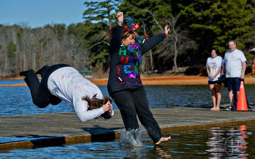Marrette Winters (left) and Traci Thomas jump into Lake Lanier during the 18th annual Polar Bear Plunge at the Lanier Canoe & Kayak Club in Gainesville on Thursday, January 1, 2015. 